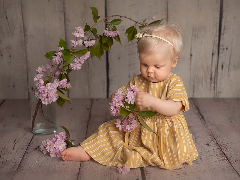 Jente i gul kjole holder blomster